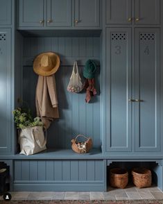 a coat rack with several coats hanging on it and two baskets in front of it