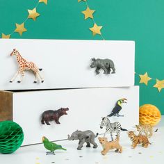 the toy animals are lined up next to each other on top of two white boxes