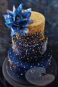 a three tiered cake with blue and gold decorations