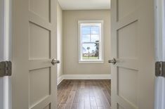 an open door leading to a room with hardwood floors