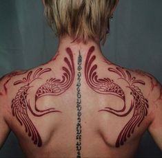 the back of a woman's neck with tattoos on her upper and lower part