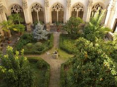 an aerial view of a garden in the middle of a building with arches and windows