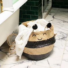 a basket with towels on the floor next to a bath tub