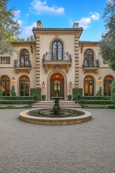 a large house with a fountain in front of it