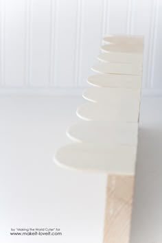 a stack of white plates sitting on top of a wooden table next to a wall