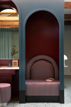 a red and white striped chair sitting in front of a mirror