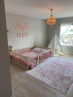 a baby's room with a teepee and pink bedding