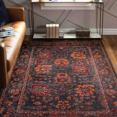 a living room area with a couch, coffee table and rug