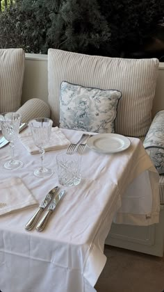 the table is set with silverware and place settings for two people to sit at