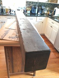 a wooden bench sitting in the middle of a kitchen