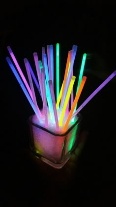 the glow sticks are glowing brightly in the dark, and it looks like they have been made out of plastic straws