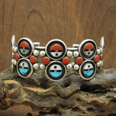 "Vintage sterling silver sun kachina mask bracelet. There are 10 sun masks with inlay. Each is 5/16\" diameter with a silver ring around it. Five are turquoise, jet and mother of pearl. Five are coral, jet and mother of pearl. There are 10 round coral inlays and 24 silver balls in the middle of the design. 5137 EG is etched inside. I don't think it is a signature but an ID from a collection. The bracelet is in good vintage condition. Thank you for looking. Please let us know if you have question Sun Mask, Inlay Jewelry, Native American Jewelry, Tucson, Indian Jewelry, Vintage Sterling Silver, Handcrafted Jewelry, Cuff Bracelet, Turquoise Bracelet