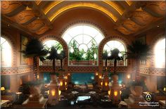 the inside of a hotel lobby with large windows and potted plants on either side