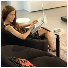 a woman sitting in a chair with a laptop on her lap