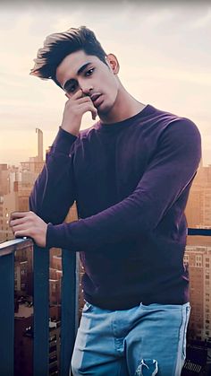 a young man standing on top of a building