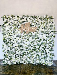 white flowers are arranged on the side of a wall