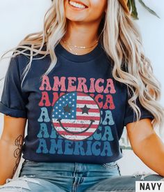 Our retro style graphic tee features an American flag smiley face design. This trendy and patriotic graphic tshirt is perfect for any 4th of July celebration, and pairs perfectly with the matching youth + toddler versions (linked below). ✩ ✩ 𝗧𝗼𝗱𝗱𝗹𝗲𝗿 𝗕𝗲𝗹𝗹𝗮 𝗖𝗮𝗻𝘃𝗮𝘀 𝗧𝗲𝗲: https://starrieapparel.etsy.com/listing/1708158002 ✩ 𝗞𝗶𝗱𝘀 𝗕𝗲𝗹𝗹𝗮 𝗖𝗮𝗻𝘃𝗮𝘀 𝗧𝗲𝗲: https://starrieapparel.etsy.com/listing/1722787629 ✩ 𝗔𝗱𝘂𝗹𝘁 𝗕𝗲𝗹𝗹𝗮 𝗖𝗮𝗻𝘃𝗮𝘀 𝗧𝗲𝗲: https://starrieapparel.etsy.com/listing/1722794367 Smiley Face Shirt, 4th Of July Shirt, Retro Smile Face Trendy Vintage Graphic Tee Cute Summer Fourth T-shirt Plus Size USA Happy Face Tshirt ✩ Our shop uses direct-to-garment printing to make our products. The design ink is sprayed on, then allowed to soak into the fibe Fourth Of July Tshirt Designs, Casual Letter Print Tops For Veterans Day, Fun Blue T-shirt For 4th Of July, Patriotic Screen Print Tops For Memorial Day, Patriotic 4th Of July Graphic T-shirt, Veterans Day Graphic Tee With Flag Print, Americana Cotton T-shirt With Letter Print, Fun Blue Tops For 4th Of July, Labor Day Americana Crew Neck T-shirt