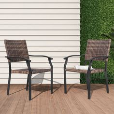 two chairs sitting next to each other on top of a wooden floor near a house