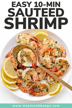 a white plate topped with shrimp and lemon wedges next to a serving spoon on top of it