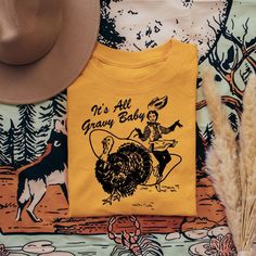 Get Ready To Wrangle In Some Serious Thanksgiving Style With Our Exclusive Its All Gravy Baby Retro Cowgirl Lasso T-Shirt! Embrace The Holiday Spirit With A Touch Of Vintage Flair And Make A Bold Statement At Your Thanksgiving Gathering. Let Your Inner Cowgirl Shine As You Rope In The Holiday Spirit And Show Off Your Unique Style. Add A Touch Of Retro Charm To Your Thanksgiving Ensemble And Capture The Hearts Of All Your Fellow Trendsetters. Trust Us; This Is The Must-Have Piece To Make Your Tha Cowgirl Lasso, Thanksgiving Shirt Ideas, Dolly Parton Shirt, Baby Thanksgiving, Thanksgiving Style, Turkey Leg, Thanksgiving Gathering, Retro Cowgirl, Closet Outfits