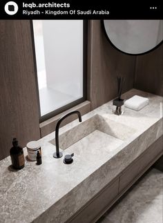 a bathroom sink with two faucets and soap dispensers