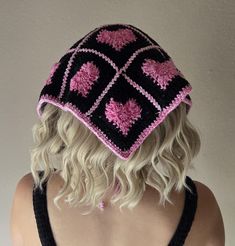 a woman wearing a black and pink crocheted hat