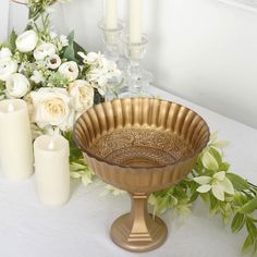 a table with candles, flowers and vases sitting on it's side next to a candle holder