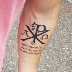 a person with a tattoo on their leg that has an inverted cross and two crossed swords