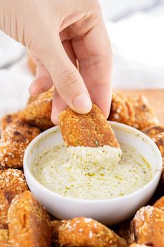 a person dipping some food into a bowl