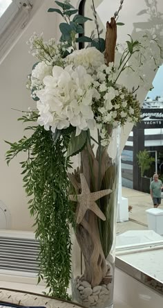 a vase filled with white flowers sitting on top of a table next to a mirror