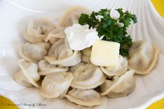 dumplings with butter and parsley in a white bowl