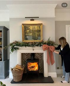 a woman standing in front of a fire place