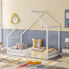 a child's bed with a white frame and a clock on the wall