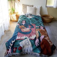 a bed covered in a blanket with pictures on it