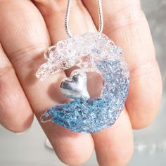 The ocean wave blown glass pendant with sterling silver 925 heart is perfect for ocean inspired style. The great wave mermaidcore jewelry is a waterproof necklace from blown glass. The heady glass pendant is an unique holiday gift idea for surfers, scuba diver, mermaids, sea and ocean lovers.  Size: 1.2″x1.2″ = 30×30 mm Materials: glass, sterling silver 925, hypoallergenic steel (a chain) All ocean vibe jewelry are handcrafted by me in my studio in Aveiro, Portugal. Please note that all jewelry Handmade Clear Heart-shaped Jewelry, Ocean-inspired Silver Glass Jewelry, Ocean-inspired Silver Glass Necklace, Heady Glass, Beachy Jewelry, Gifts For Surfers, Blown Glass Pendant, Unique Holiday Gifts, Silver Heart Pendant