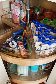 an organized kitchen drawer with food and drinks in the bottom shelf, including milk, eggs, yogurt, cereals, juice, and more