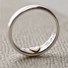 Secret Message Silver and Gold Personalised Ring, Engraved Ring, Couple's Ring, Personalised Ring with Names, Christmas Gift For Her A very special handcrafted, personalised silver ring, with a secret 9ct gold heart inside that can leave an imprint on your finger when removed. We will make your ring to order, with your choice of either a stunning gold or silver heart inside your ring. Your words will be hand stamped, letter by letter, either side of the heart, and we will hand finish your ring in either a polished, hammered or brushed matt finish. Your message can use letters, numbers and spaces up to 8 characters either side of the heart. Perfect for discreet messages and special dates. Made From: Sterling Silver band with a sterling silver or 9ct gold heart. Dimensions:  1.7mm x 5mm Suit Open Heart Ring Engraved For Wedding, Personalized Silver Rings For Wedding, Personalized Silver Rings For Marriage, Anniversary Rings With Hallmarks And Round Band, Stamped Promise Ring, Stamped Open Ring For Anniversary, Engraved White Gold Heart Ring For Anniversary, Stamped Round Band Ring For Anniversary, Engraved Couple Rings For Marriage