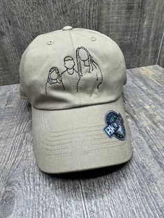 a baseball cap with the image of two women on it, sitting on a wooden surface