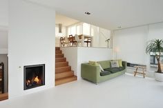 a living room filled with furniture and a fire place next to a stair case in front of a fireplace