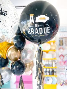 some black and gold balloons are hanging from the ceiling