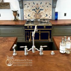 a kitchen with an old fashioned stove, sink and faucet in the center