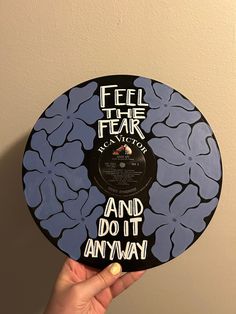 a hand holding up a record that says feel the fear and do it any way