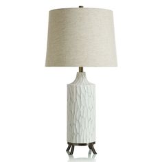 a white table lamp with a beige shade