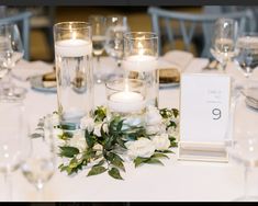 the table is set with candles, flowers and place cards for guests to sit at