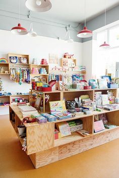 the children's book store has many books on shelves and lights hanging from the ceiling