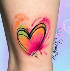 a heart tattoo on the side of a woman's leg with colorful paint splatters