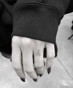 a person's hand with a small tattoo on the middle finger and an arrow in the middle