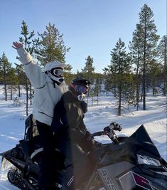 two people riding on the back of a snowmobile