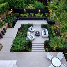 an aerial view of a patio with seating and fire pit in the center, surrounded by greenery