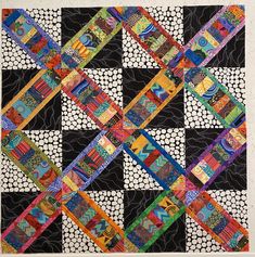 a black and white quilt with multicolored squares on it's sides,